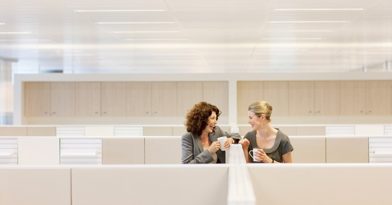 Coworkers gossiping between cubicles