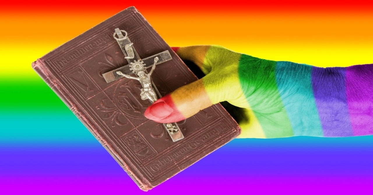 hand covered in rainbow paint holding a bible with rainbow background
