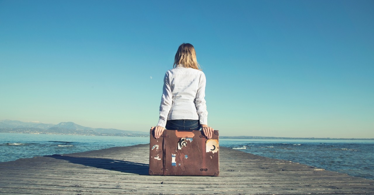 Woman sitting on a suitcase