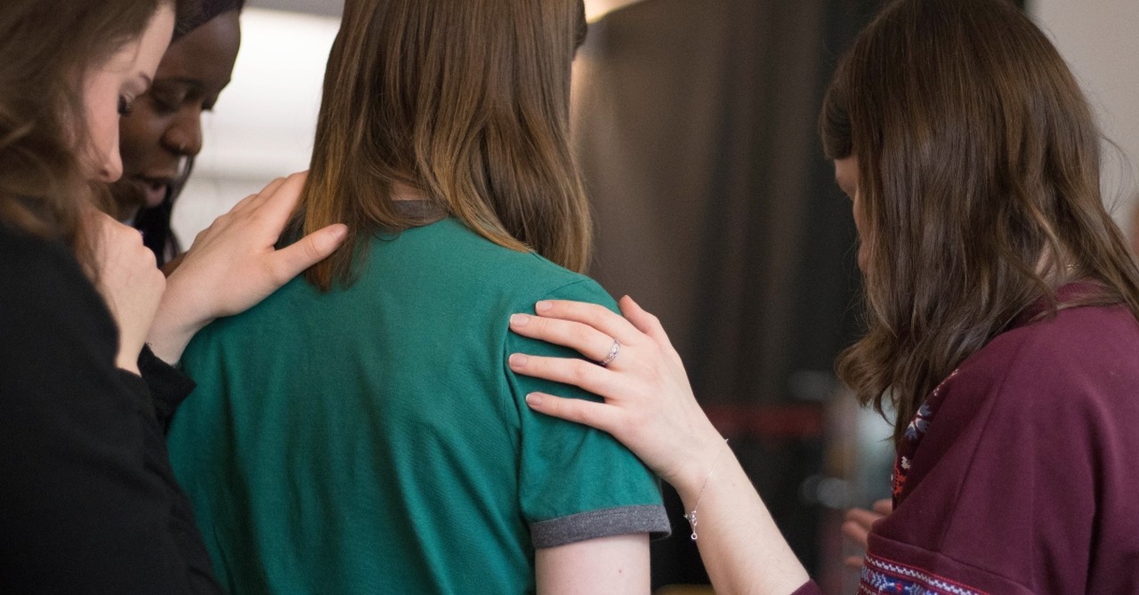 Women praying together, ways that normalization of anxiety can help and ways that it can hurt