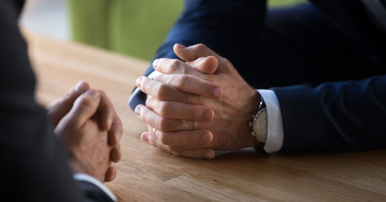 Two hands folded in discussion, decisinos to make before leaving a church