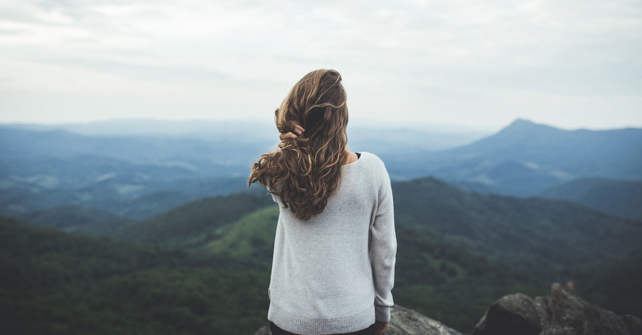 woman looking out at mountains in nature