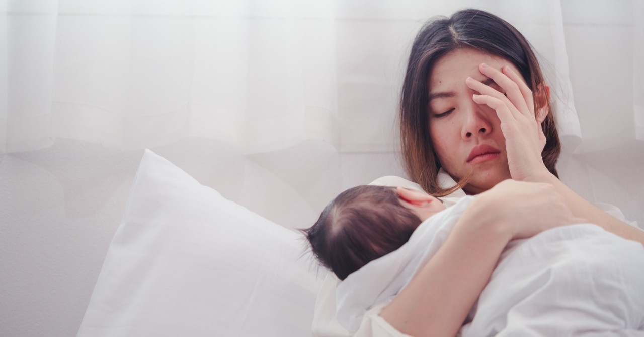 Tired, stressed out mom holding a baby