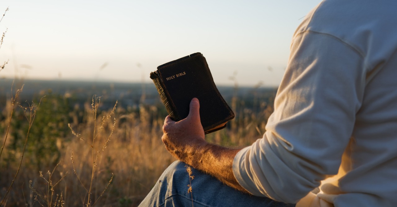 man holding a Bible,