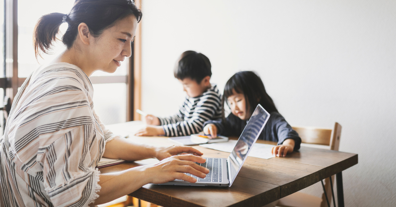 A busy mom working while her kids do homework.