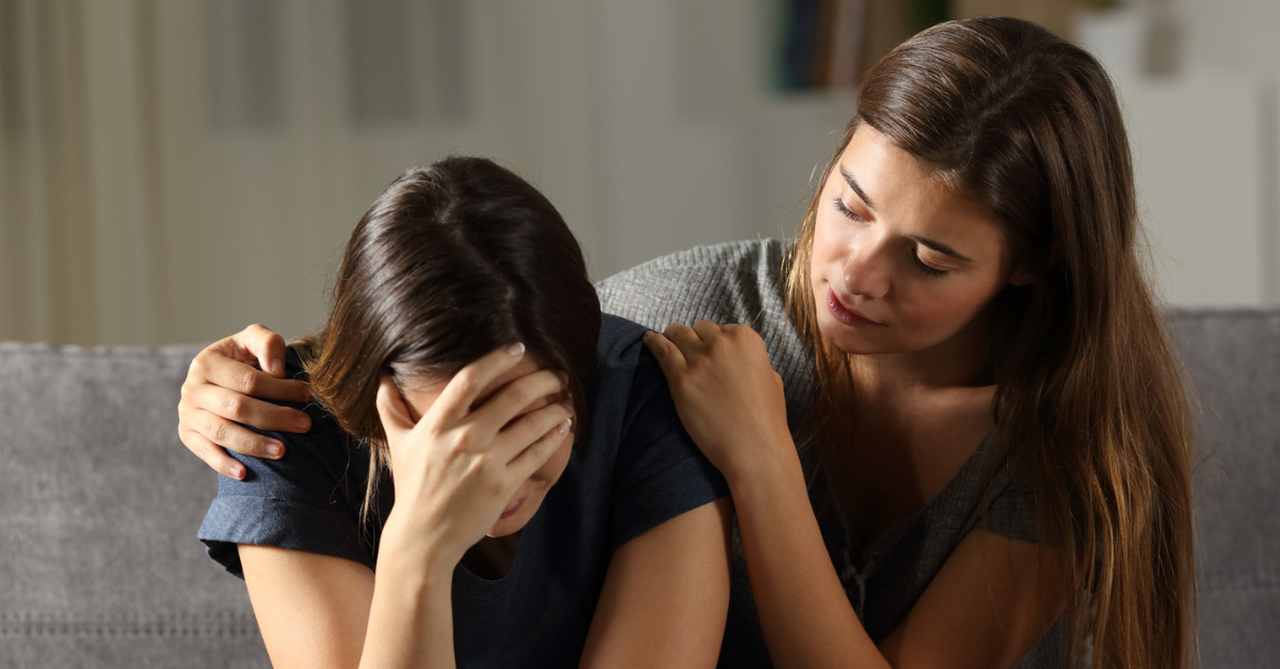 Woman serving in love by comforting another.