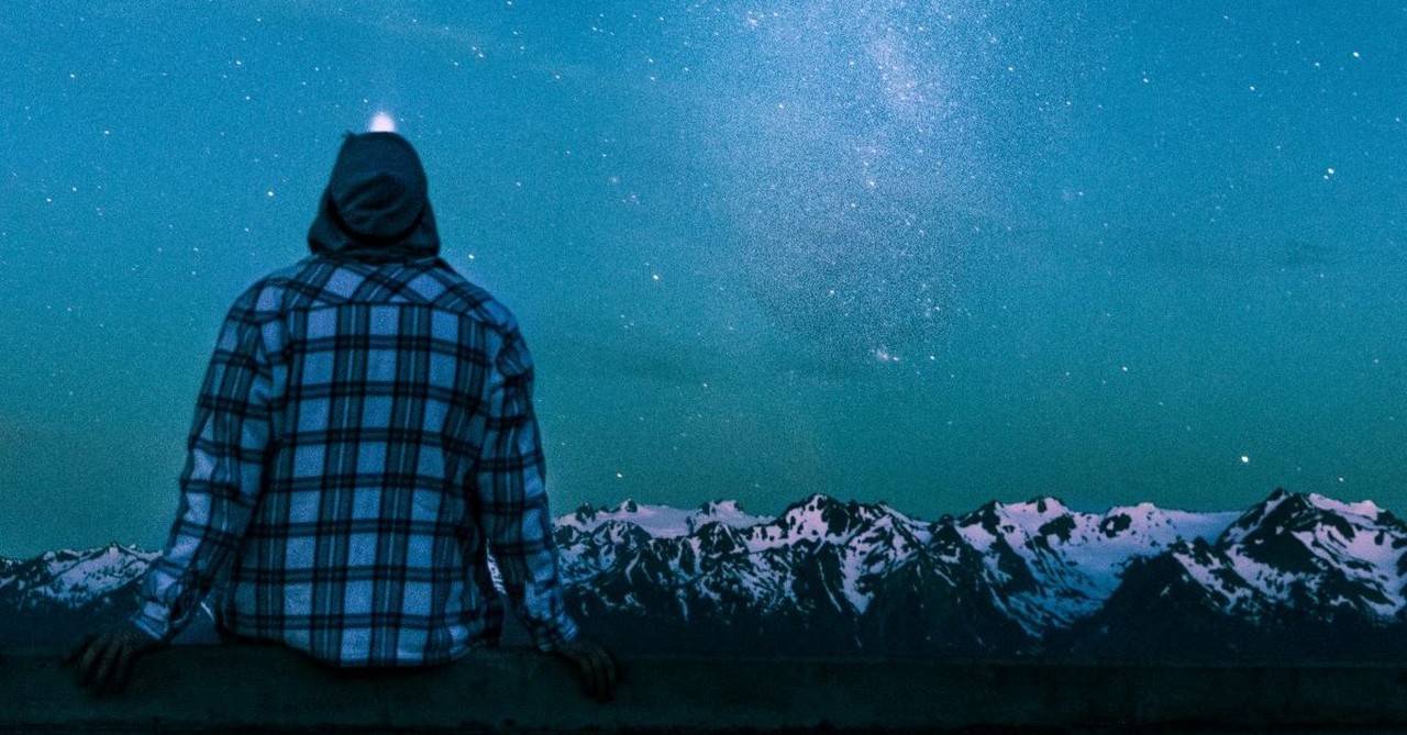 man looking up night sky and stars