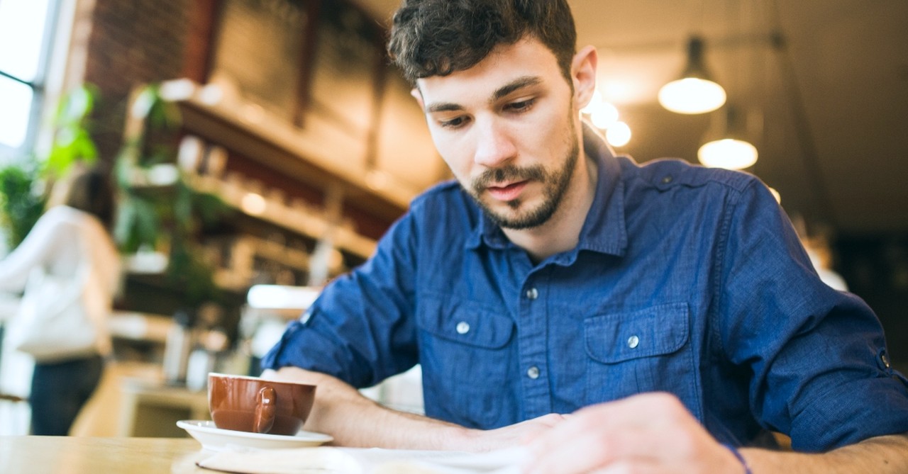 Man reading a Bible in a coffee shop