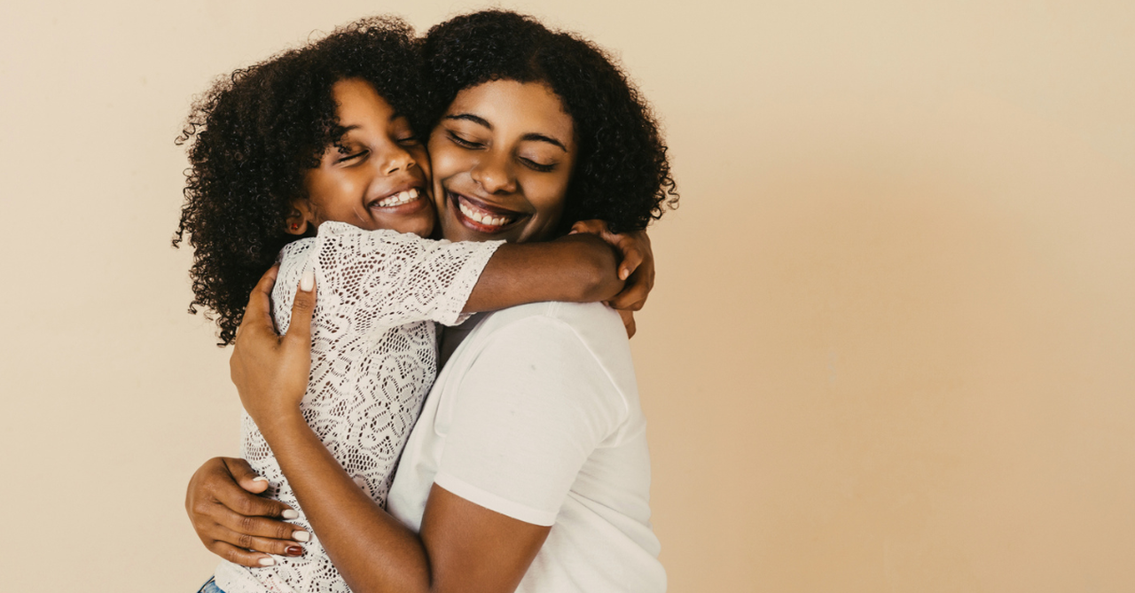 Mom and teen daughter hugging and smiling.