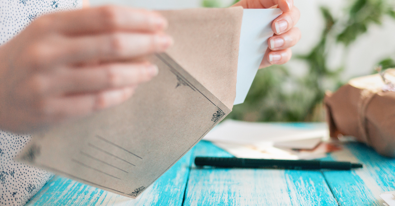 Woman putting a letter in an envelope.