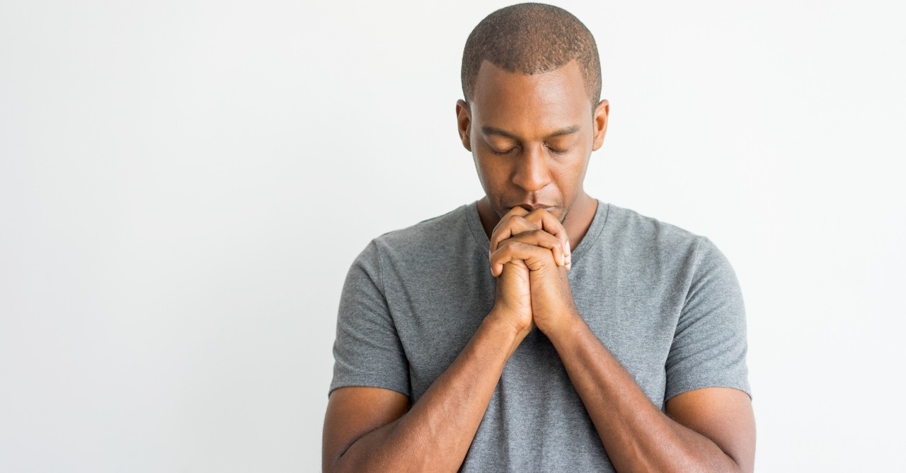 Man praying with hands folded