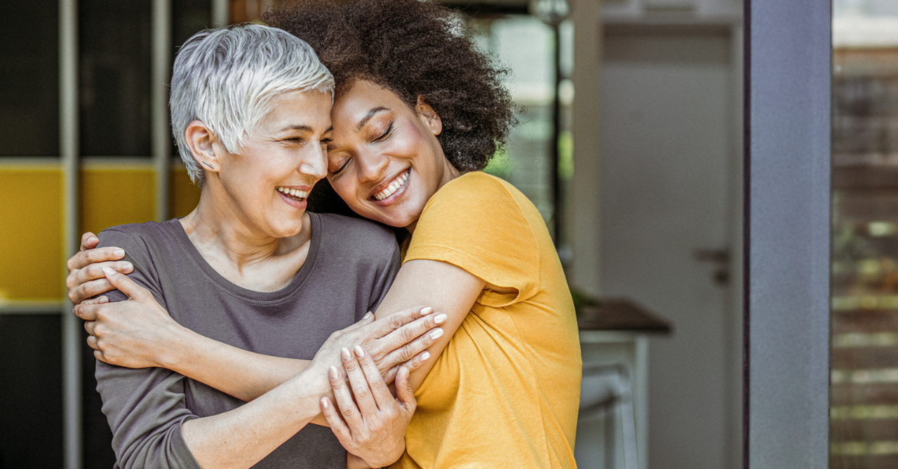 Two friends hugging and smiling/laughing;