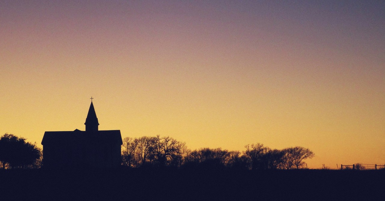 a church building silhouetted against the sunset