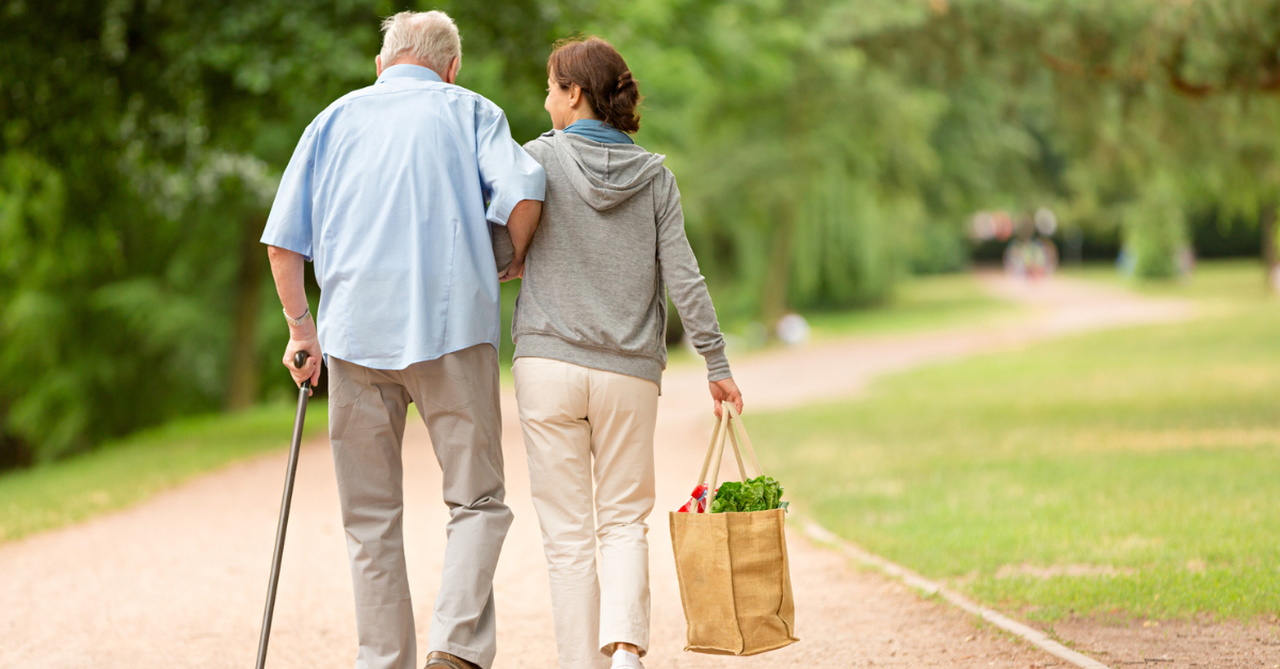 Woman helping elderly man with groceries