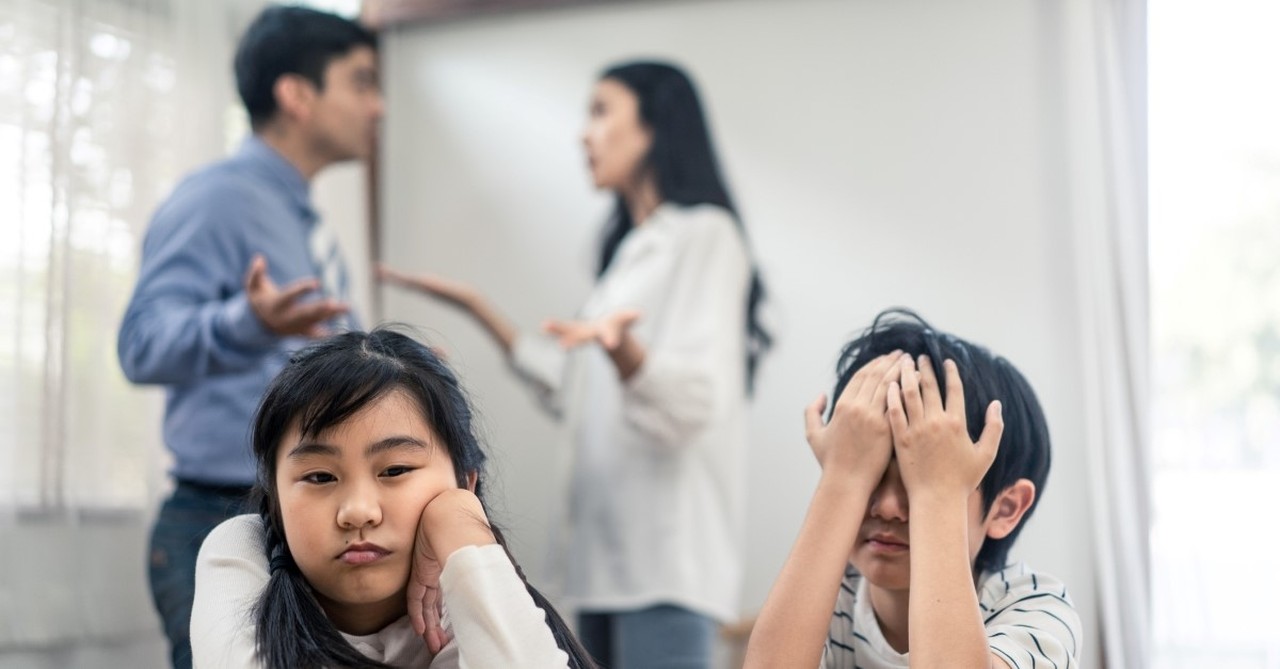 sad children with arguing parents in background, marriage health little moments