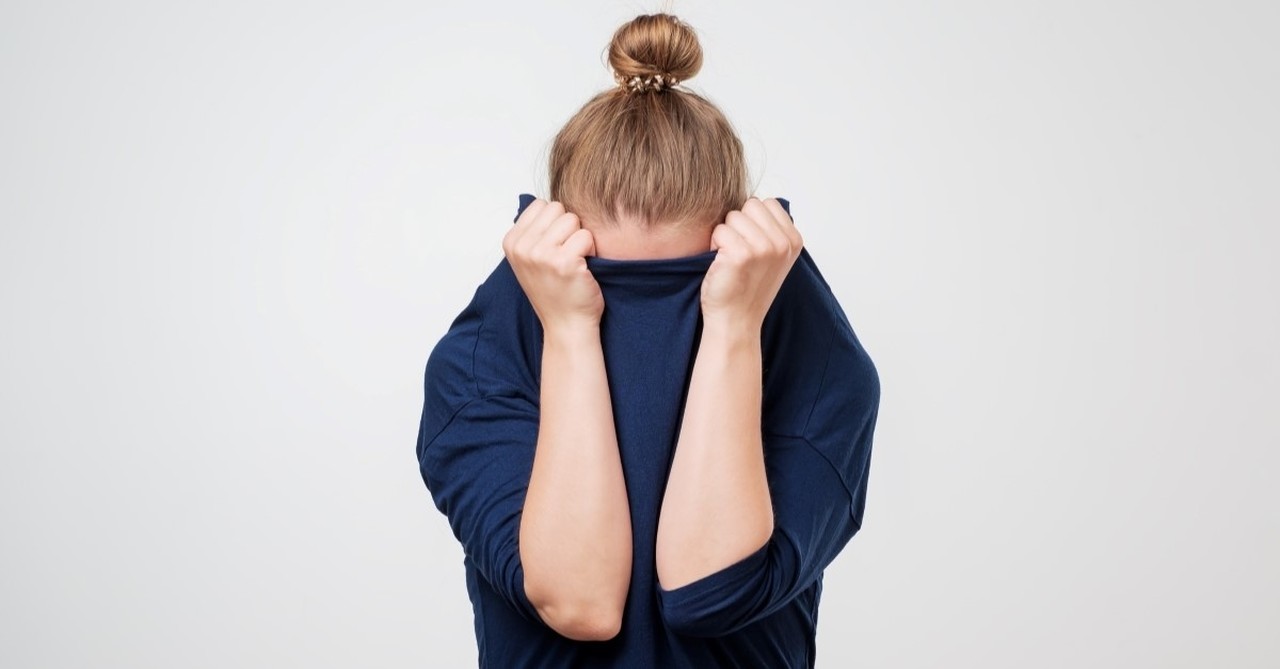 woman hiding face in shirt, signs you are seeking approval