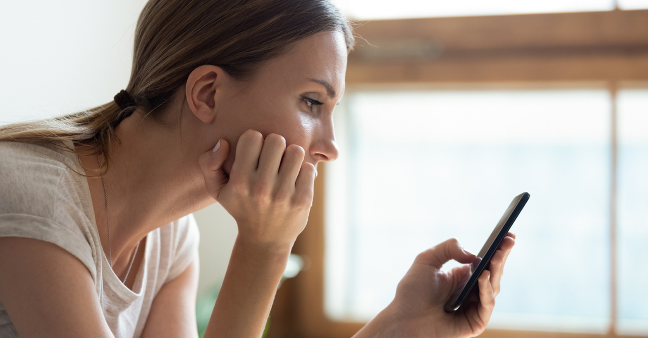 Woman staring at her phone; strategies to resist comparison.