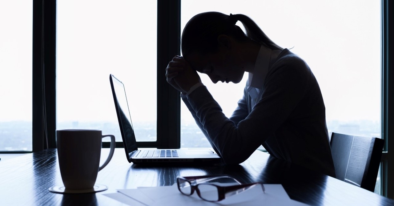 stressed woman praying at table, warning signs of legalism