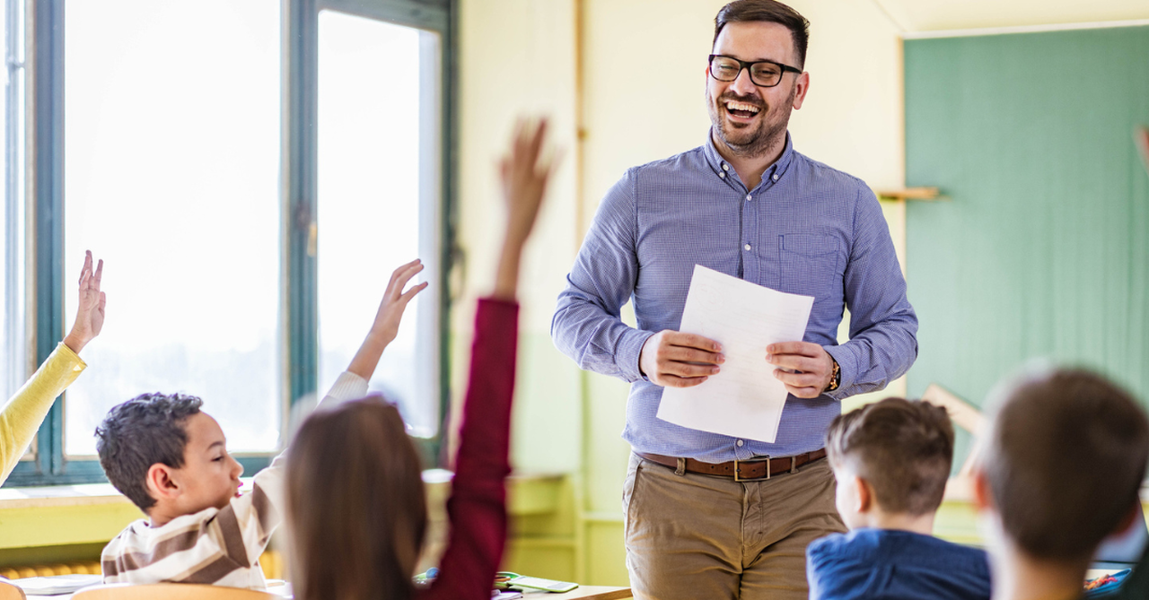 Male teacher smiling as he teaches his elementary class; a teacher's advice for Christian parents.