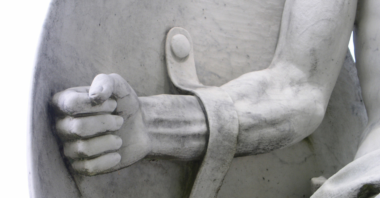 Stone sculpture of a warrior holding a shield; experiencing a spiritual attack in your home.