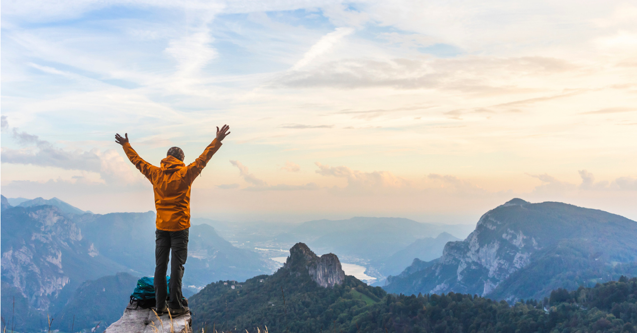 Man on top of a mountains; 5 ways to build resilience in leaders.