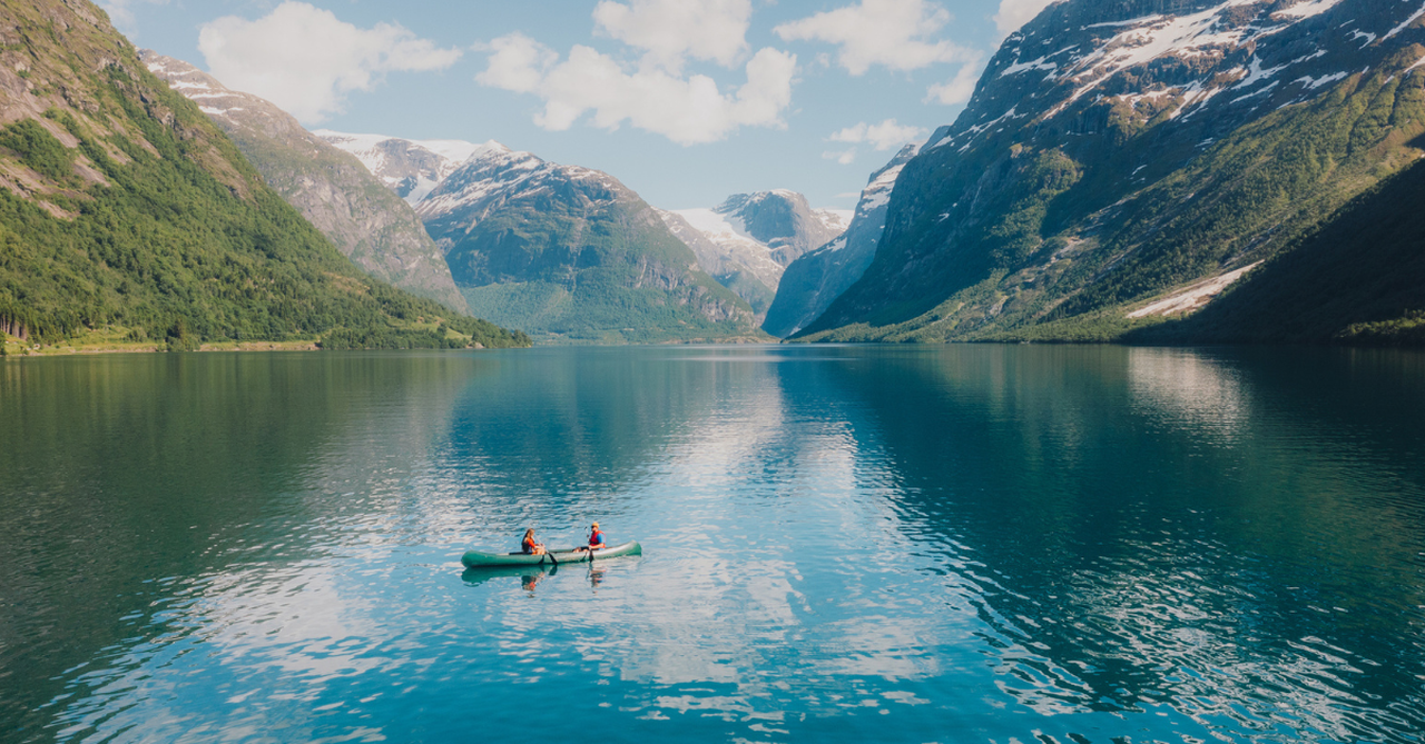 Kayakers in nature; mountains and a beautiful blue lake