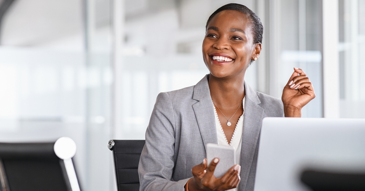 Business woman in her office, smiling; living out Christian values in the workplace.