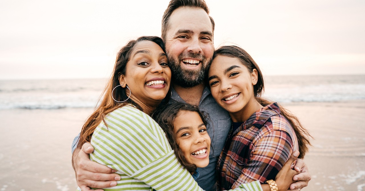 Happy family hugging daughters teen