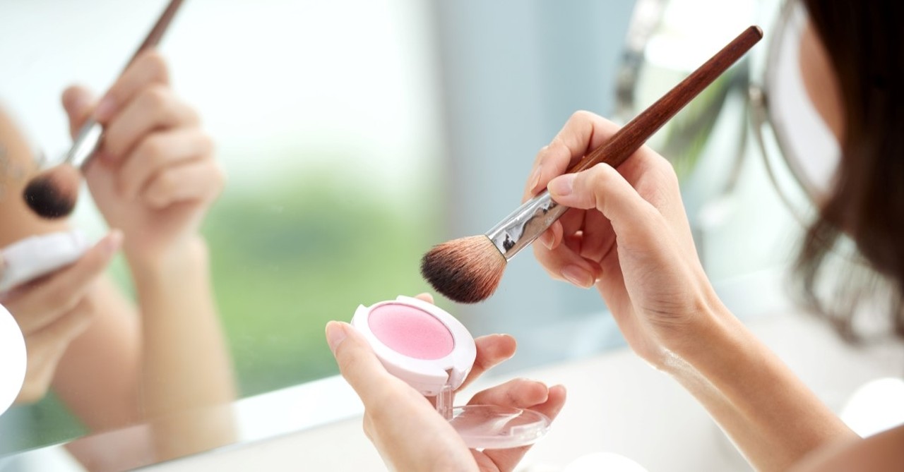 woman applying makeup to illustrate article on what does the bible say about makeup