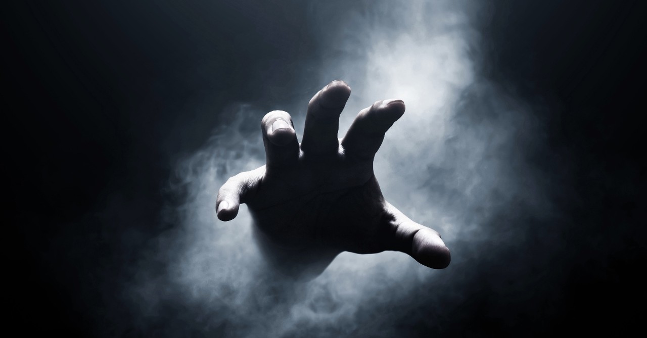 Hand coming out of a dark background