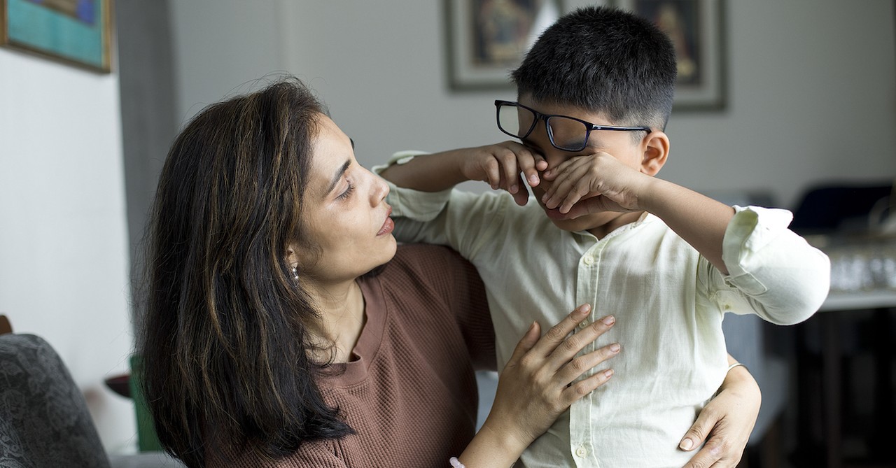 Mom comforting son crying child