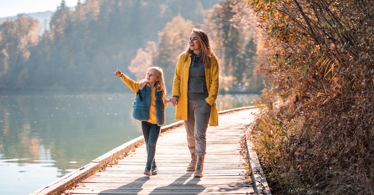 Fall mom and daughter taking walk in nature