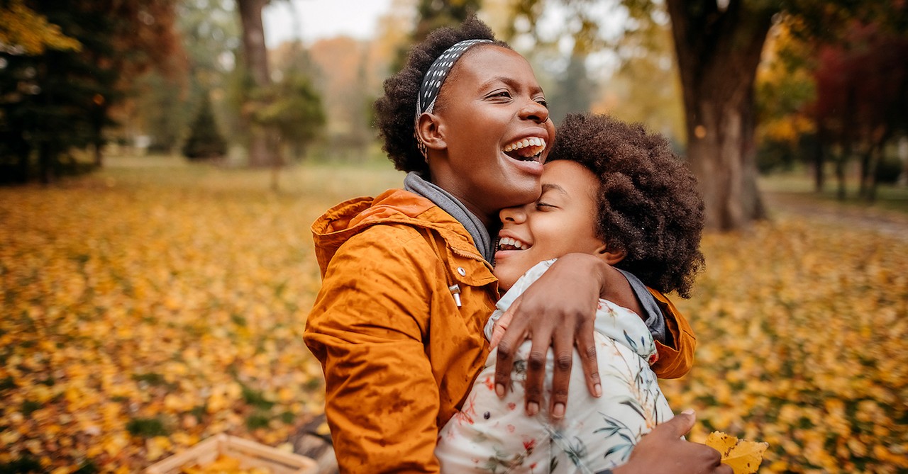 Mom and teen daughter hugging in fall