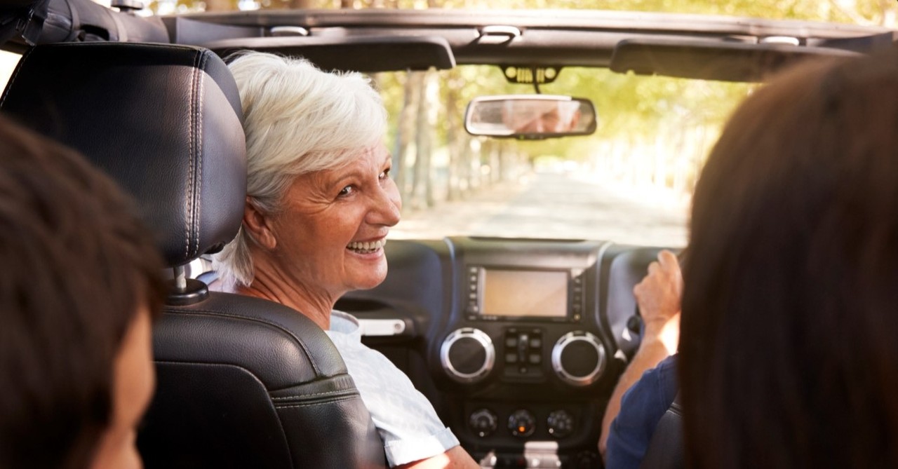 Grandmother in a car, looking back and smiling