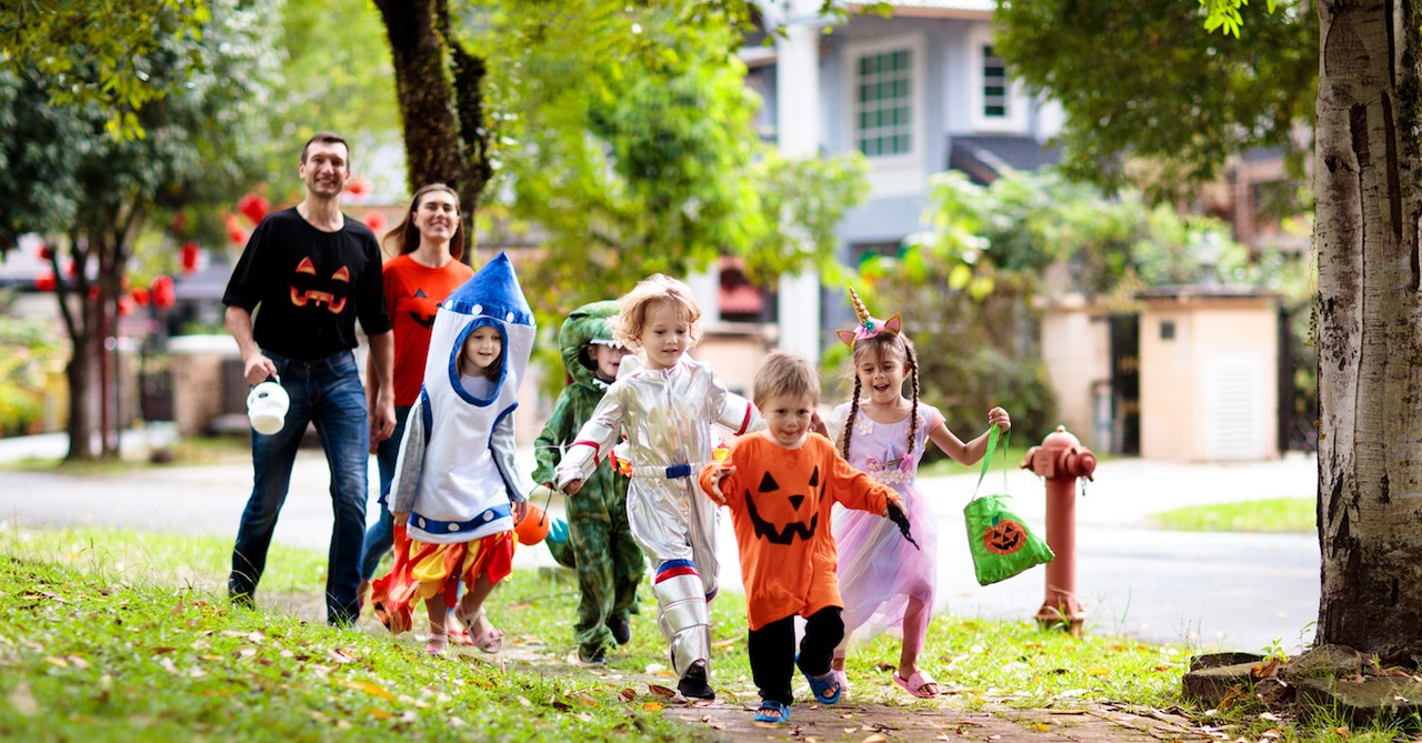 family trick or treating in neighborhood on halloween