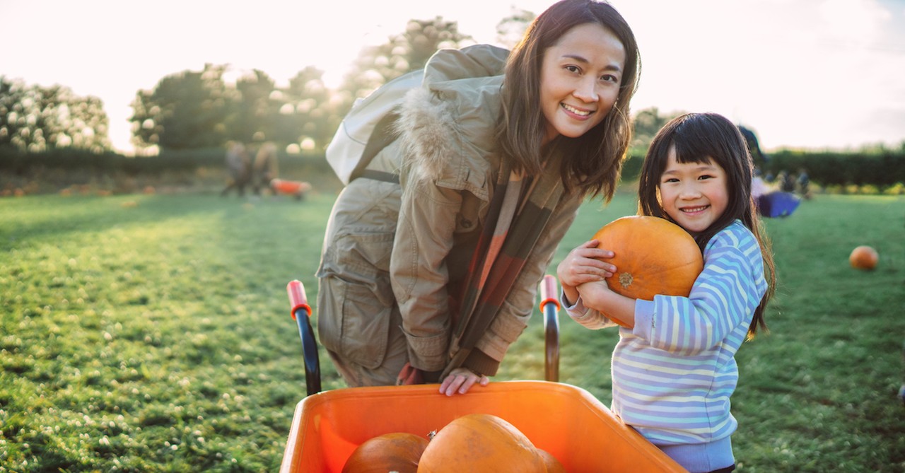 mother and daughter getting pumpkins at pumpkin patch