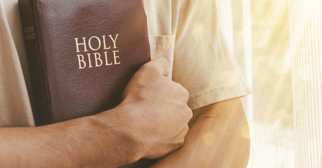 Man holding a Bible;