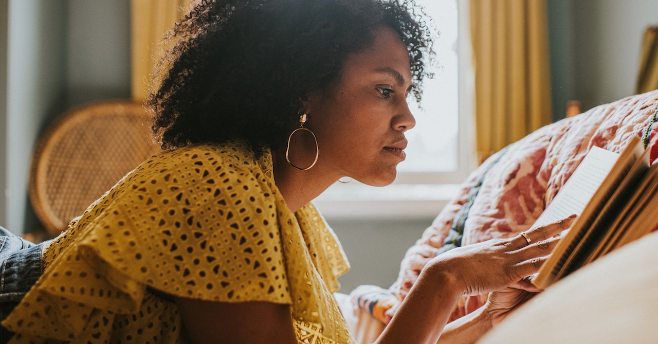 Woman reading book on bed