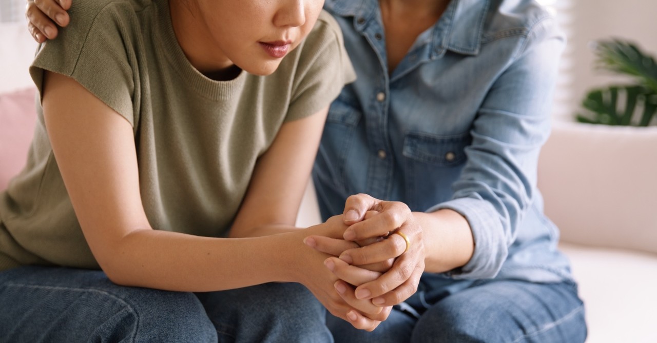 One woman comforting another as they talk