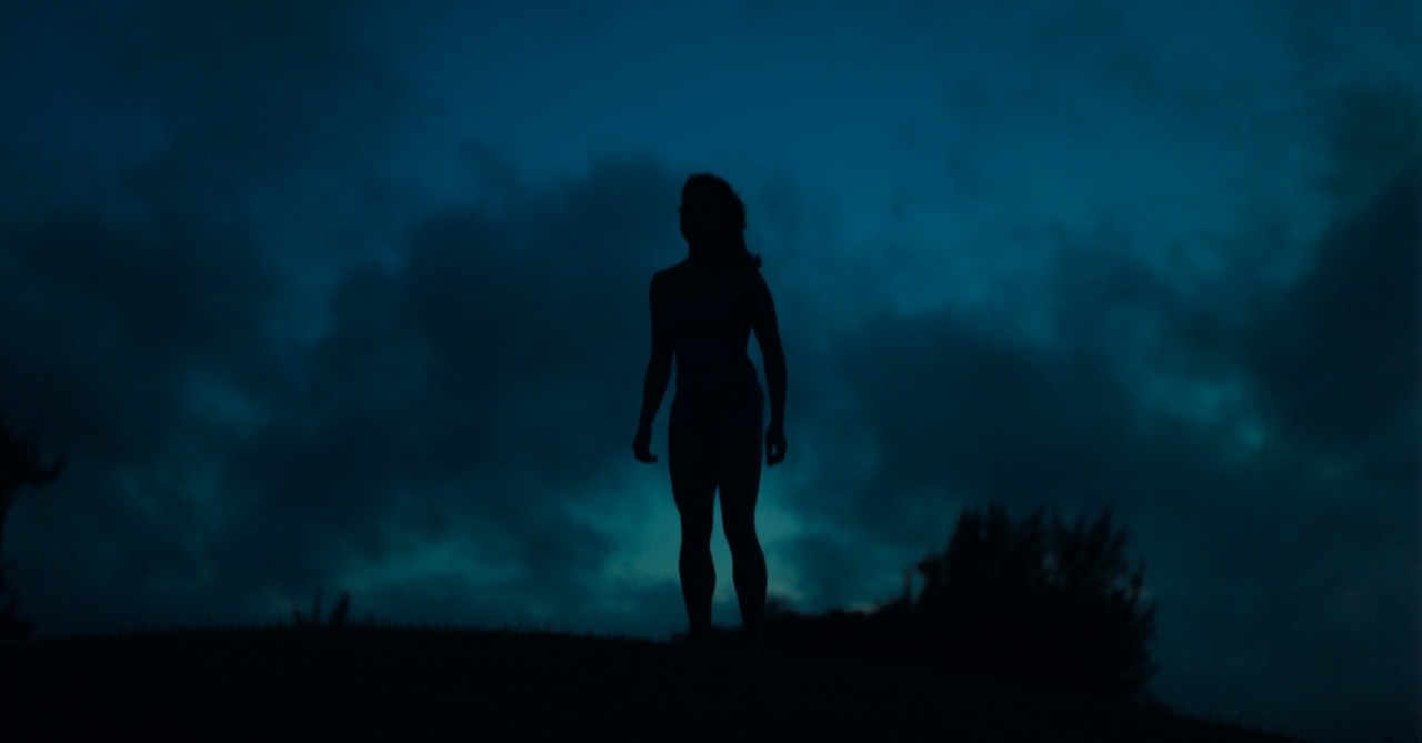 Silhouette of a woman outside in the dark