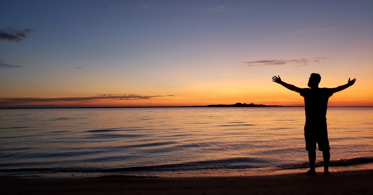 man worshipping God at beach