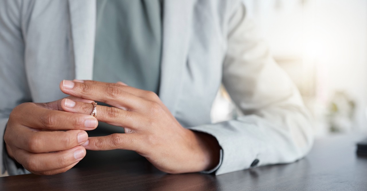 Woman sliding off her wedding ring