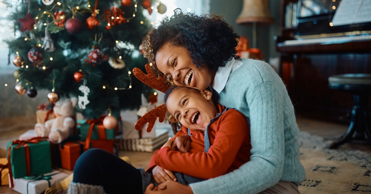 Mom holding her son by the Christmas Tree