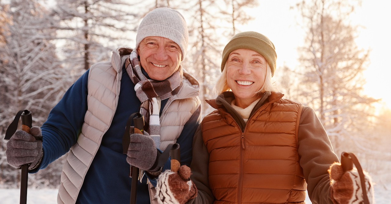 Happy senior couple on winter walk date in the snow hiking