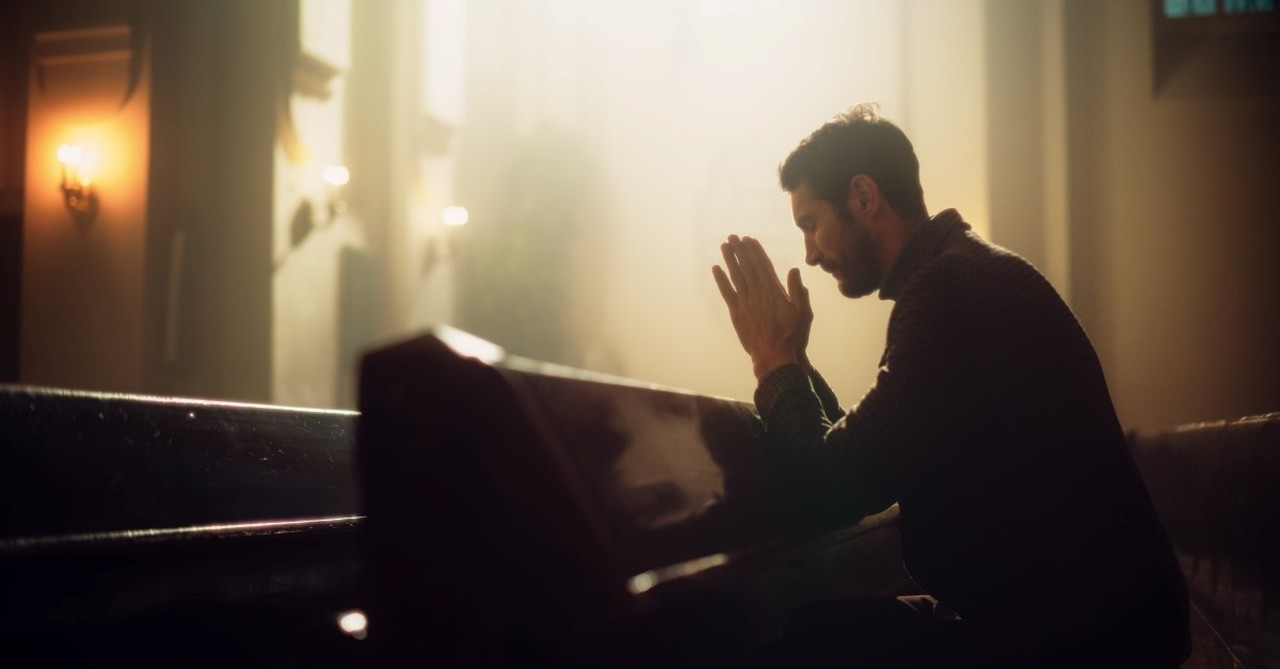 man praying in church