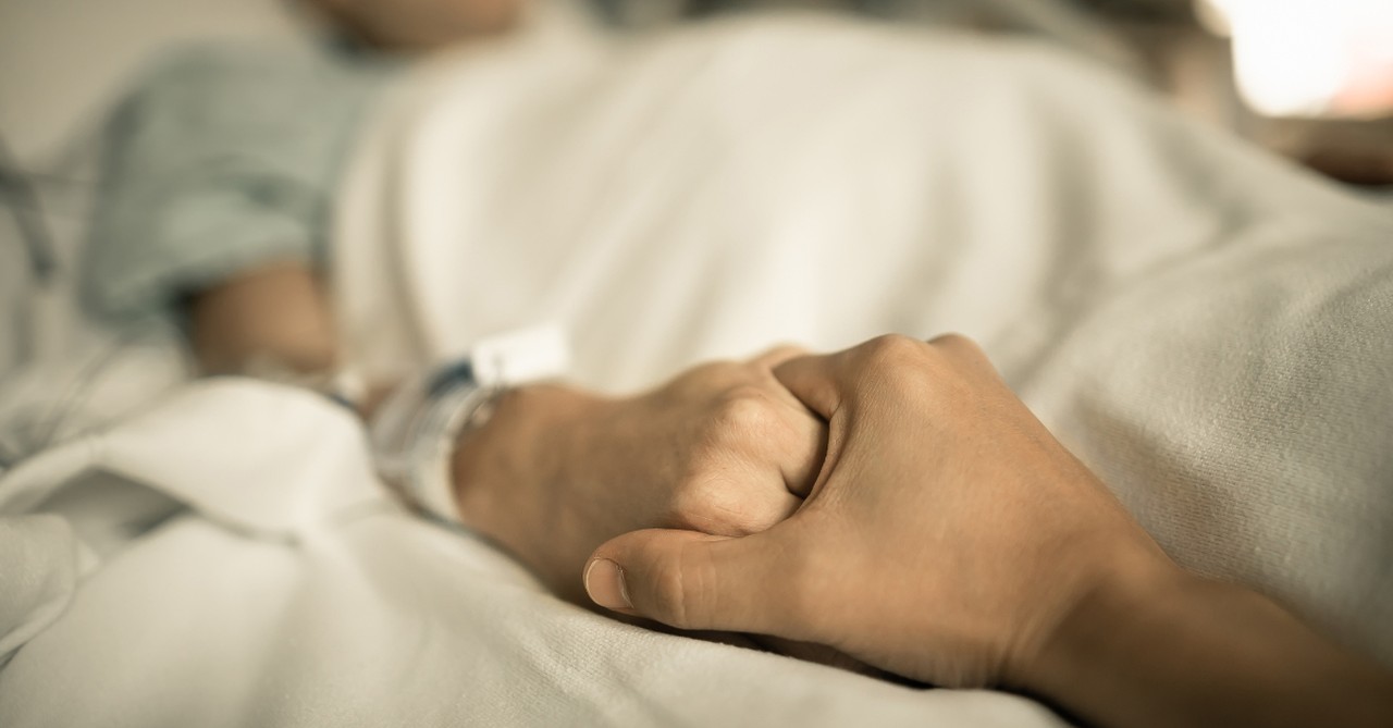 holding hand of dying loved one