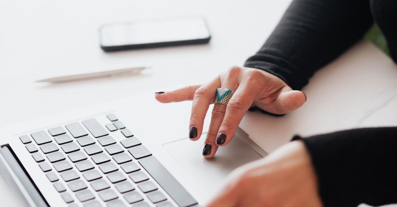 Close-up of woman working on a laptop.