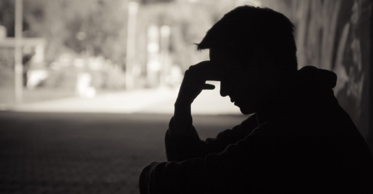 silhouette of stressed man sitting under tree, signs of the end times