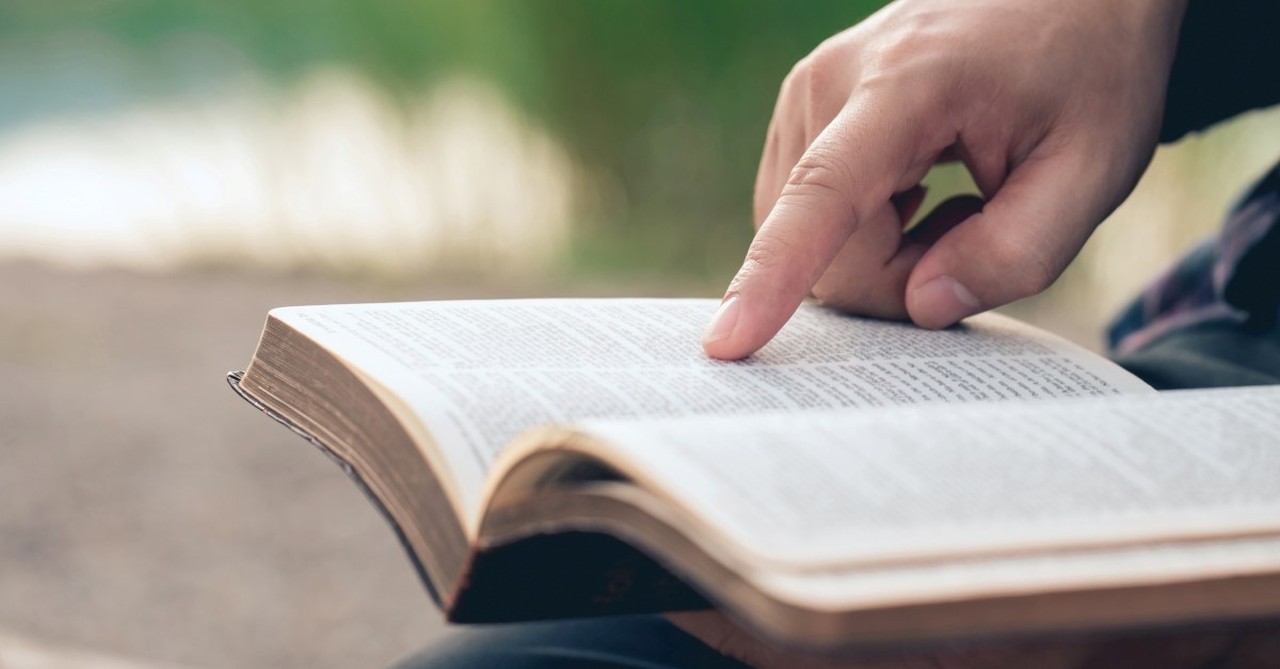 man's hand reading bible