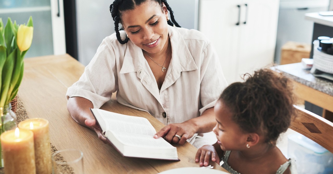 Mom parent and kid daughter reading Bible teaching